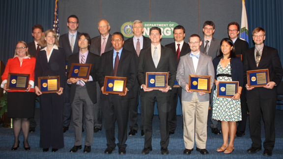 2011 PECASE winners holding their awards standing with DOE leadership on a stage (Ceremony: 8/1/12).