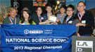 A group of students and teachers holding a banner that reads "National Science Bowl 2013 Regional Champion".