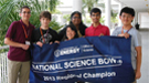 A group of students and teachers holding a banner that reads "National Science Bowl 2013 Regional Champion".
