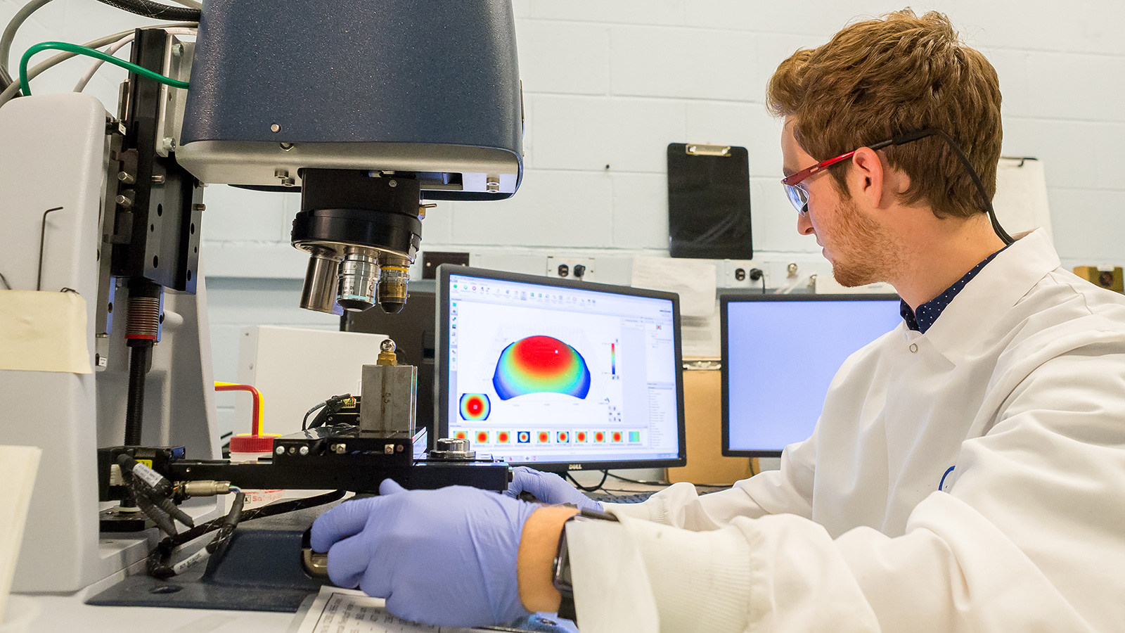 Sam Kizlaitis, chemical engineering student at the University of Illinois at Urbana-Champaign, examines wear damage on bearings at Argonne. (Image by Argonne National Laboratory.)