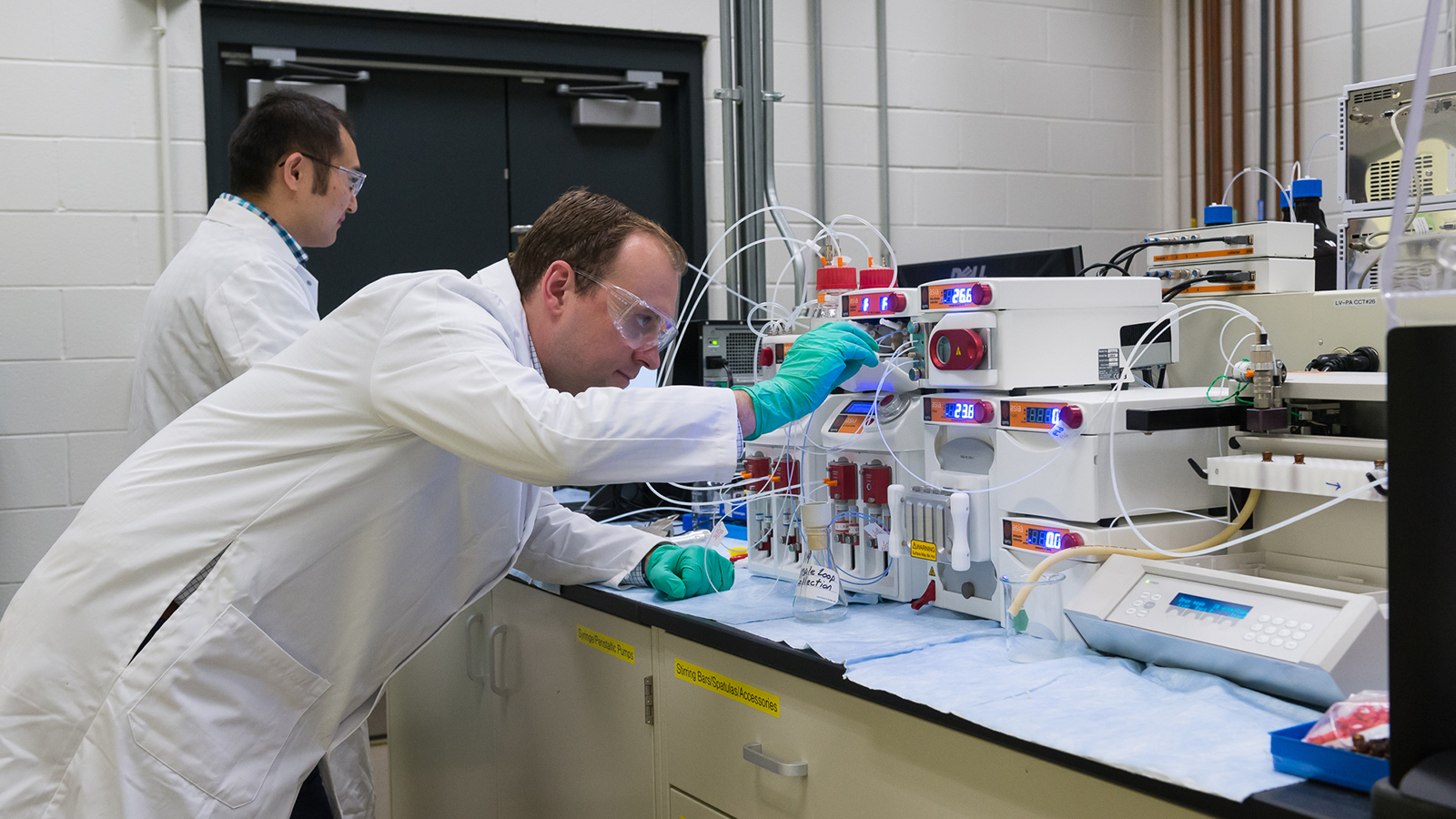 Two men working with Argonne’s Continuous Flow Reactor 