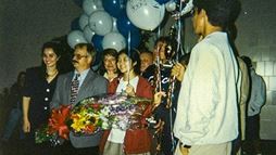 Candice Kamachi (in red coat) and her teammates were greeted as they arrived home in California after winning the 1996 National Science Bowl&reg; in Washington, D.C.
