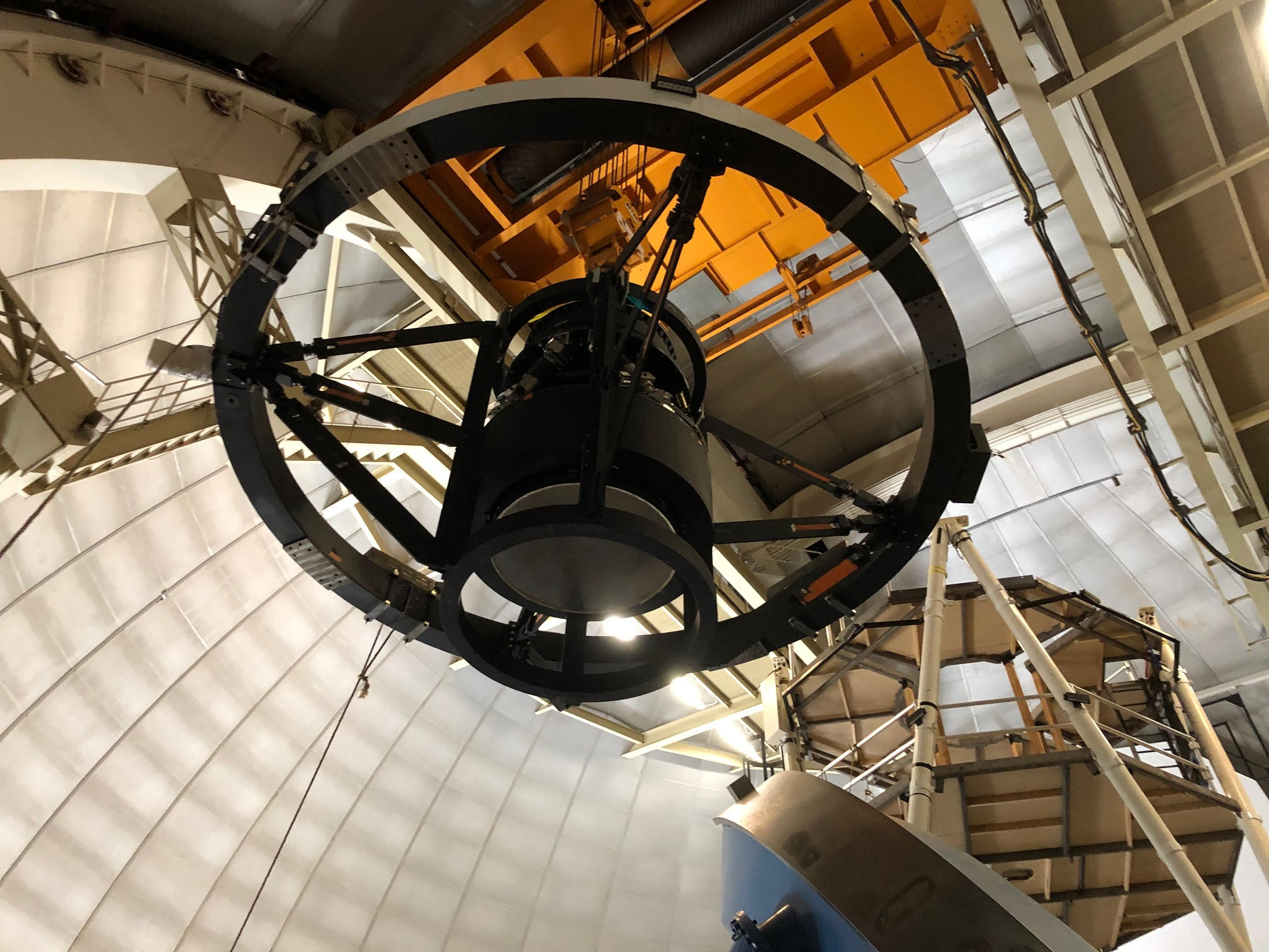 Crews at the Mayall Telescope near Tucson, Arizona, lift and install the top-end components for the Dark Energy Spectroscopic Instrument, or DESI. The components, which include a stack of six lenses and other structures or positioning and support, weigh about 12 tons. DESI, scheduled to begin its sky survey next year, is designed to produce the largest 3-D map of the universe and produce new clues about the nature of dark energy. (Credit: David Sprayberry, NOAO/AURA)