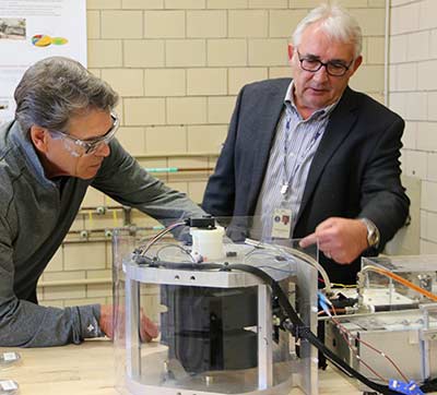 Ames Laboratory scientist Vitalij Pecharsky (right) explains the CaloriSMART system to Energy Secretary Rick Perry during a tour of Ames Laboratory.