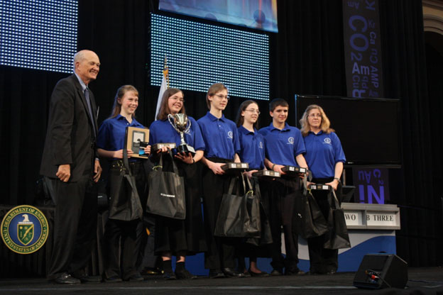 Students stand on stage with Dr. Brinkman holding prizes for winning Civility Award