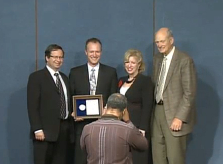 Senior leadership with a PECASE winner posing for a photograph