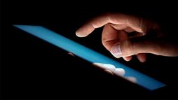 An image of a hand over a touchscreen.